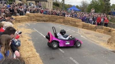 A boy in a purple go-kart