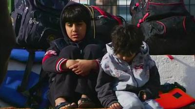 Migrant children waiting with luggage