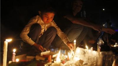 2 Afgans light candles during a memorial for the victims of a suicide bomb blast, in Kabul, Afghanistan, 23 July 2016