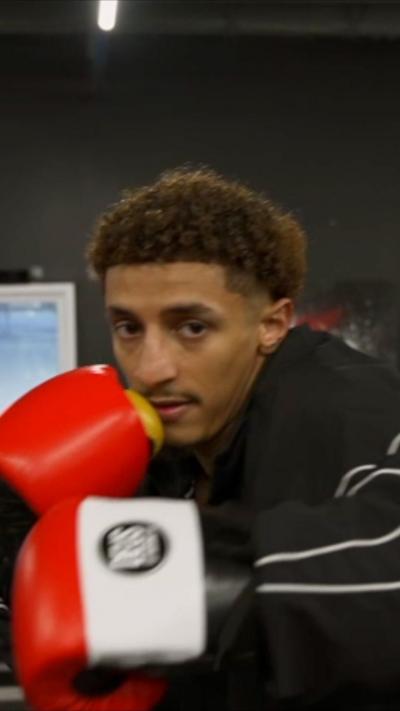 Said Abdullah in a black jacket and red boxing gloves in a ring preparing to throw a punch