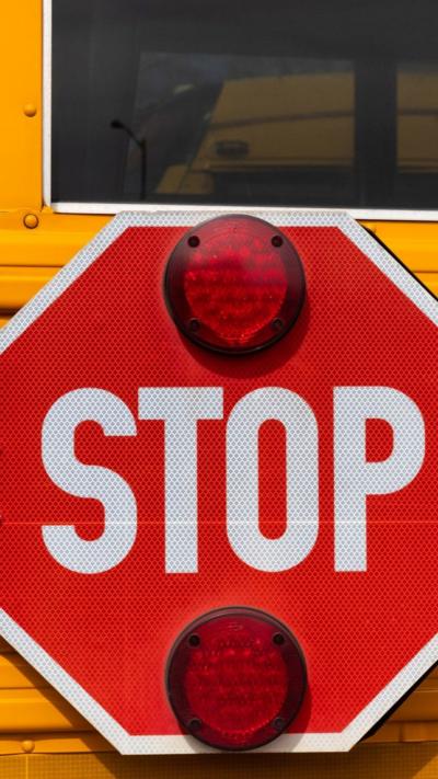 A red stop sign on a yellow school bus