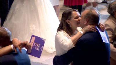 A middle-aged couple kiss after renewing their vowels with 79 other couples at Coventry Cathedral