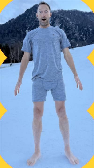A man wearing shorts and underwear in the snow, with a shocked expression.
