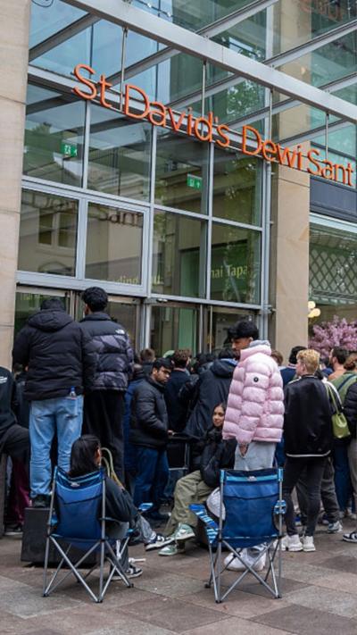 A crowd of people, including two on camping chairs, outside St David's shopping centre in Cardiff
