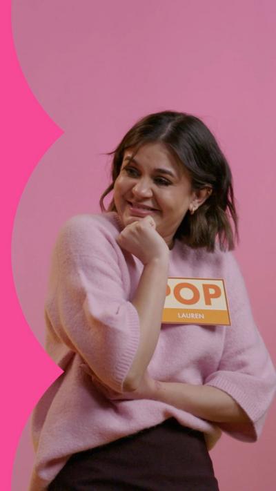 A woman with a Lauren name badge smiles in a pink jumper