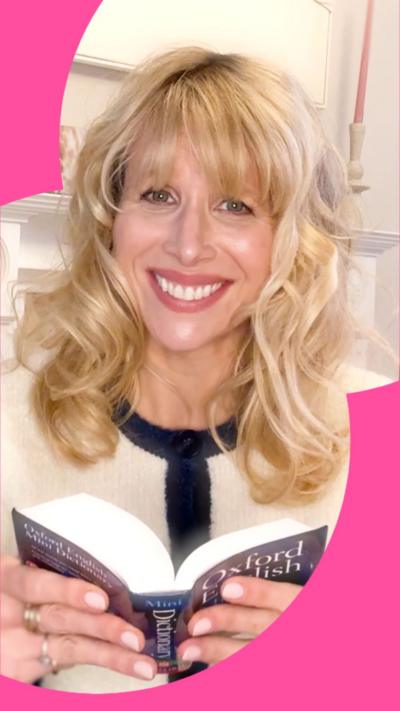 A woman with shoulder-length blonde hair gives the camera a forced smile
