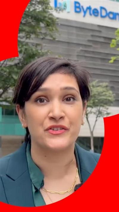Suranjana Tewari wears a green jacket standing in front of a building with a ByteDance sign on the side