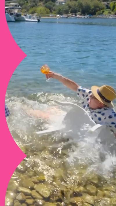 Alan Carr falls into the water wearing a hat and clothes