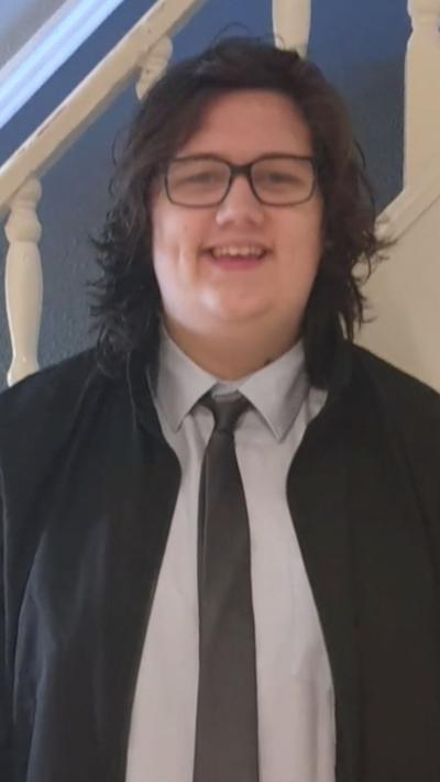 A young man in a suit, with black hair and glasses.