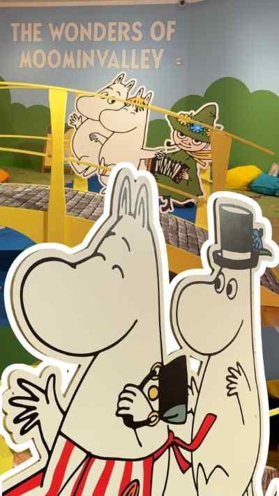 A brightly coloured indoor play exhibit themed “The Wonders of Moominvalley” features a small yellow bridge with cartoon Moomin characters and a tent-like play area in the background.
