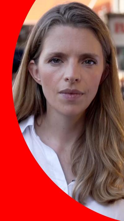 Carrie Davies has long blonde hair and is wearing a white shirt.