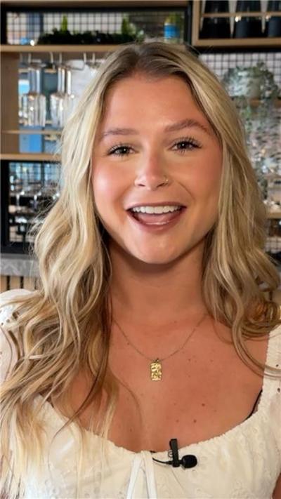 Mollie Pearce, with blonde hair, smiles into camera. She is wearing a white top.