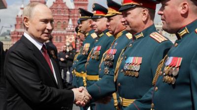 Putin shakes hands with participants in the Red Square military parade