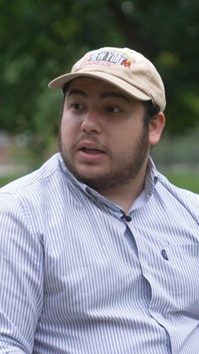 A man in a blue shirt and cream baseball cap