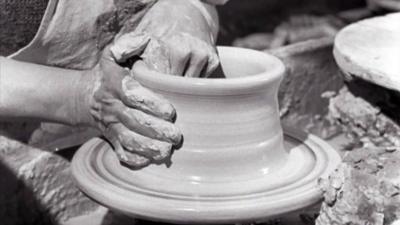 The hands of Georges Aubertin as he throws a pot