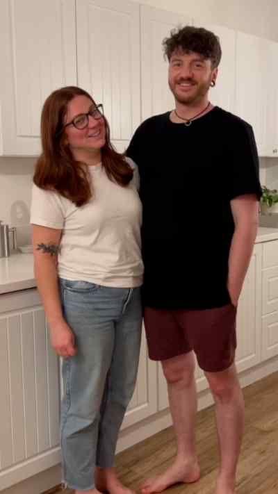 Liam and Nici stand in a kitchen smiling
