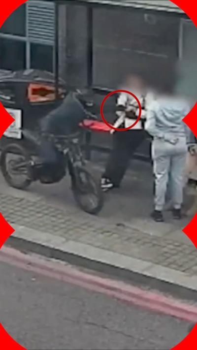 A motorcyclist grabbing a woman's phone on a London street