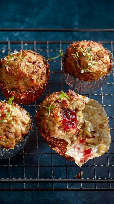 Four muffins sit on a cooling rack. One has had a bite taken out of it.