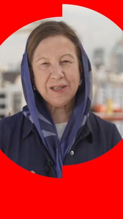 Lyse Doucet in a navy blue headscarf and coat