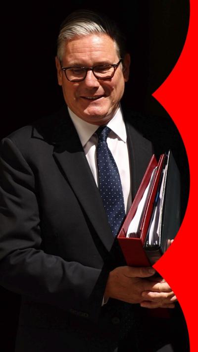Starmer carries folders and smiles