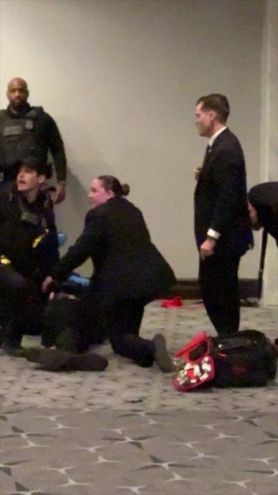 Four members of law enforcement stand around a suspected gunman.