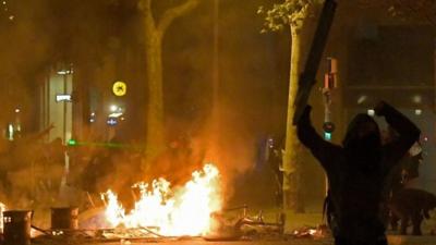 Protester by burning barricade