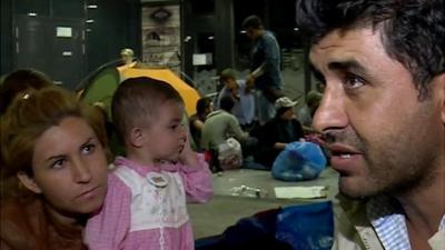 Ismail, who is from northern Syria, sits in Budapest train station with his family