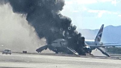 Smoke billows out from a plane that caught fire at McCarren International Airport