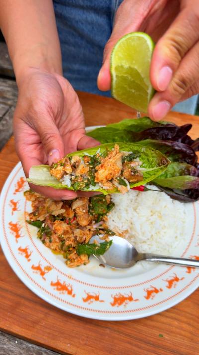 Justin Tsang's campfire fish laab salad with Justin squeezing lime over the dish