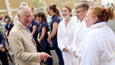 King Charles III meets employees and clients of the spa during a visit to the Duchy of Cornwall's Poundbury development in Dorset on 27 June 2023