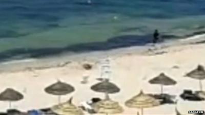 Still from footage showing Tunisia gunman running along beach