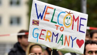 People welcome refugees with a banner reading "welcome to Germany" in Dortmund, Germany, Sunday, Sept. 6, 2015