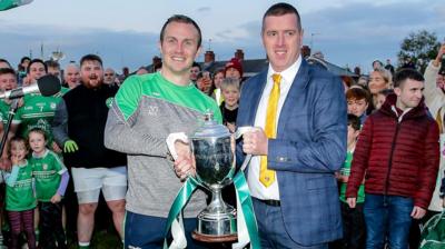 Michael McCann receives the cup from Ciaran McCavana