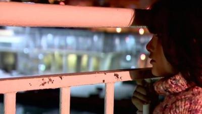 Migrant girl looks through railings