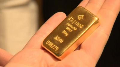 Person holding small gold bar