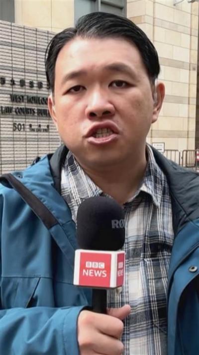 Martin Yip speaking into a hand held BBC News mirophone. 