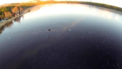 A man rescues a dog in Loch Morlich