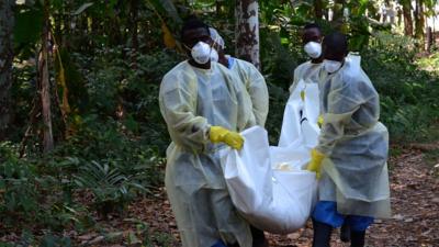 Healthcare workers carry a dead body