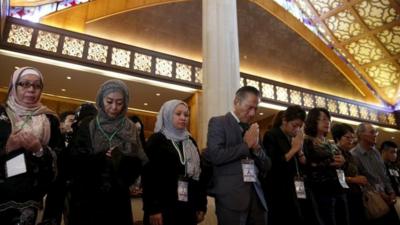 Relatives of passengers killed onboard flight MH17 pray during a memorial service