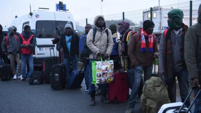 Migrants queue at the "Jungle" camp in Calais, France.