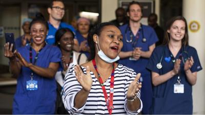 healthcare workers applaud outside a hospital in London