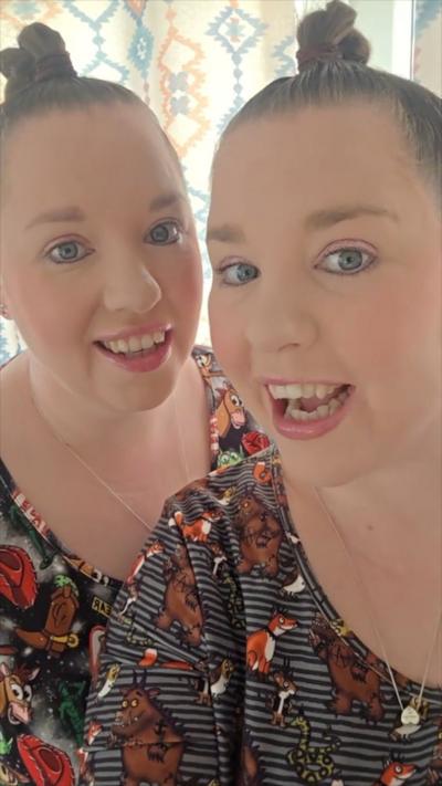 Two women that are twins both with their hair up in a bun