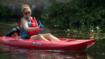 a woman paddling on a canal