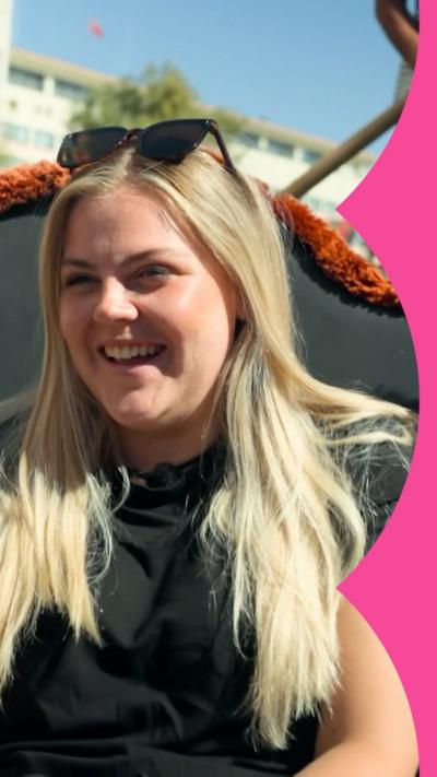 A woman with long, blonde hair smiles while sat in a gondola.