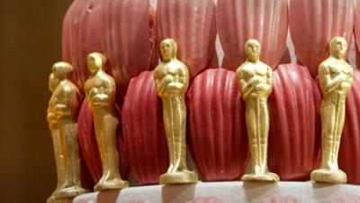 A cake decorated with edible gold Oscar statuettes