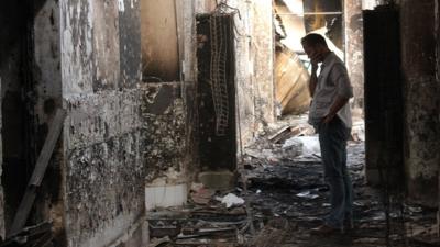 An employee of Doctors Without Borders walks inside the charred remains of their hospital after it was hit by a U.S. airstrike in Kunduz, Afghanistan, Oct. 16, 2015