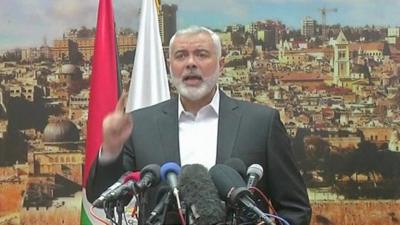 Ismail Haniya stands at a podium with microphones