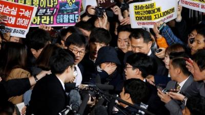 Choi Soon-sil surrounded by media and protesters