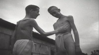 Two starving prisoners of war in loin cloths