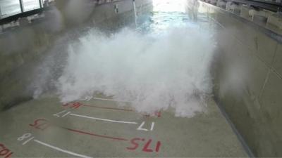 Wave crashing on wall with measuring scale